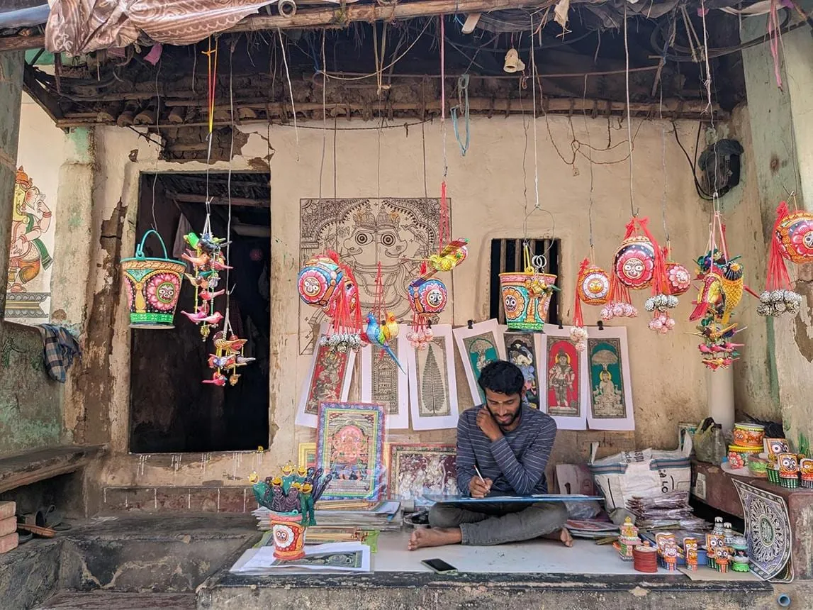 An artisan at his home workshop, surrounded by finished pieces